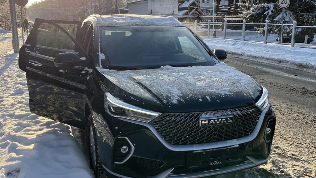 Чёрный Haval M6 с открытой дверью на заснеженной улице
